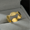 Gold ring with textured design on a gray surface